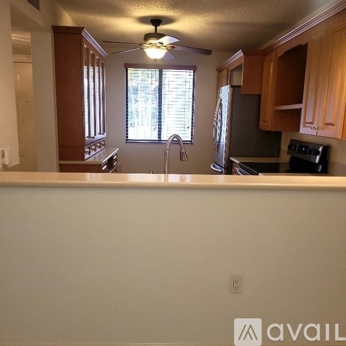 A kitchen with wooden cabinets and a stainless steel refrigerator.
