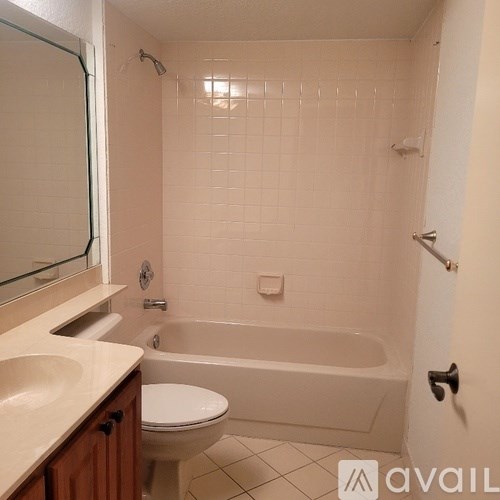 A bathroom with a tub, toilet and sink.