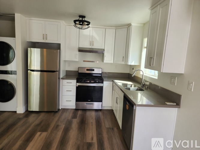 A room with wooden flooring and a washing machine in it.