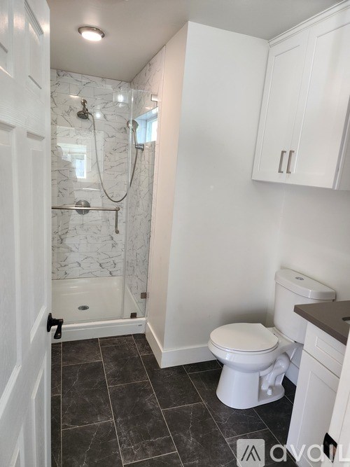 A white gate is closed with a small black handle on the right side.