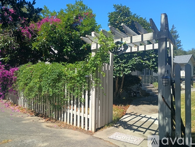 A white gate with the number 6124 on it is in front of a pathway.
