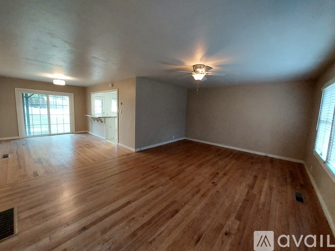 A room with wooden flooring and a ceiling fan.