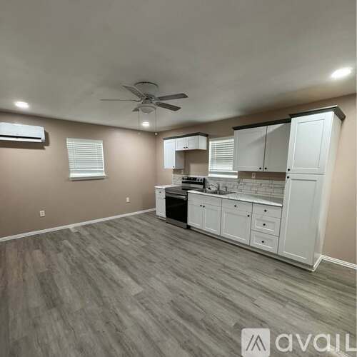 A kitchen with a fan on the ceiling and a dishwasher.