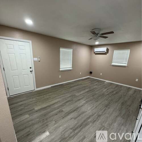 A room with a white door and a ceiling fan.