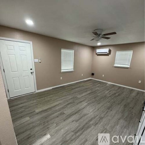 A room with a white door and a ceiling fan.