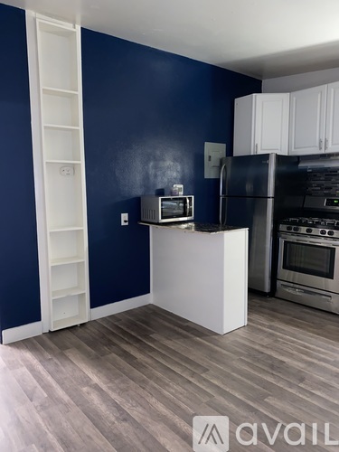 A kitchen with a white island and a refrigerator.