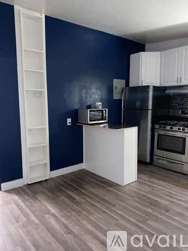 A kitchen with a white island and a refrigerator.