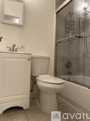 A white toilet sits next to a sink in a bathroom.