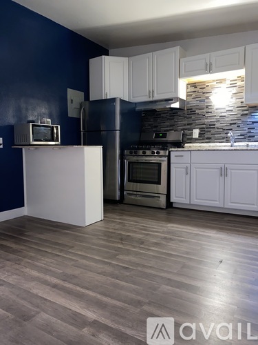 A kitchen with a white island, stove, and cabinets.