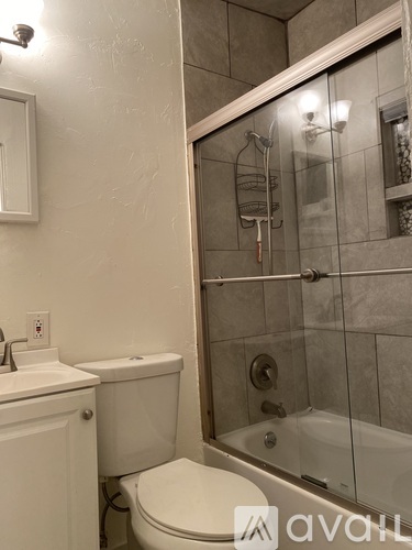 A bathroom with a toilet, sink, and shower.