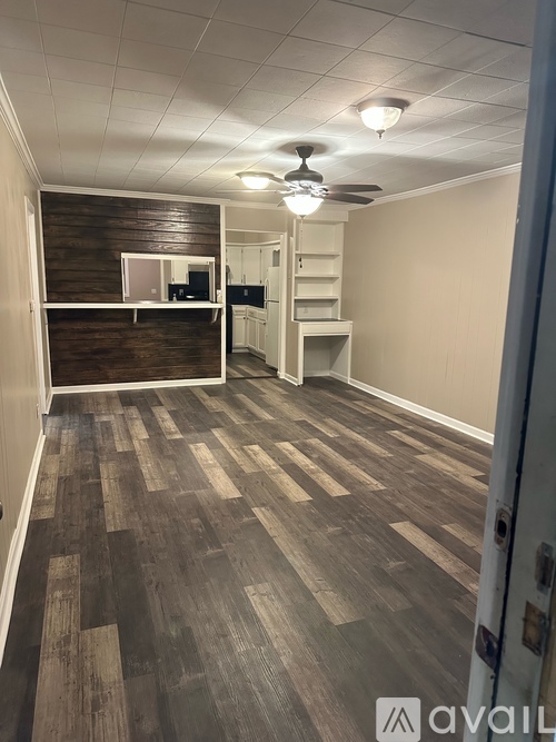 A room with wooden flooring and a ceiling fan.