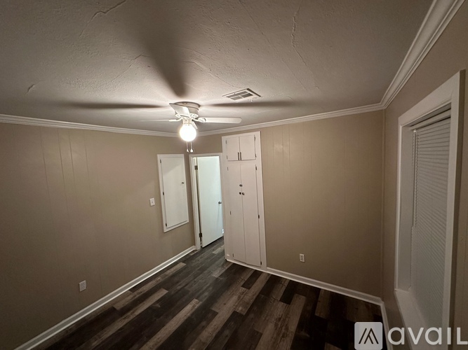 A room with a ceiling fan and a row of closets.