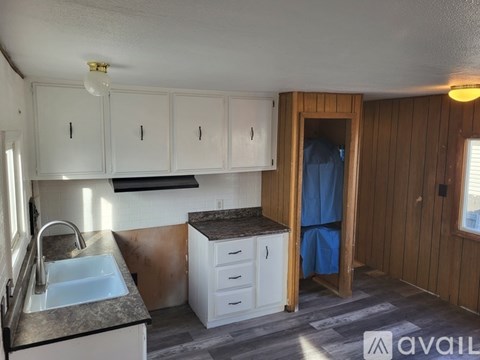 A kitchen with white cabinets and a sink.