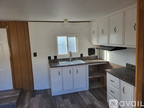 A kitchen with white cabinets and a black countertop.