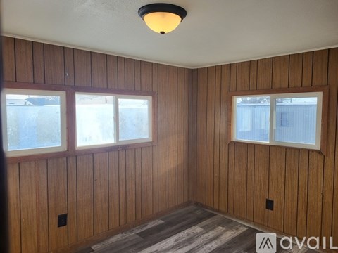 A room with wooden walls and a window.