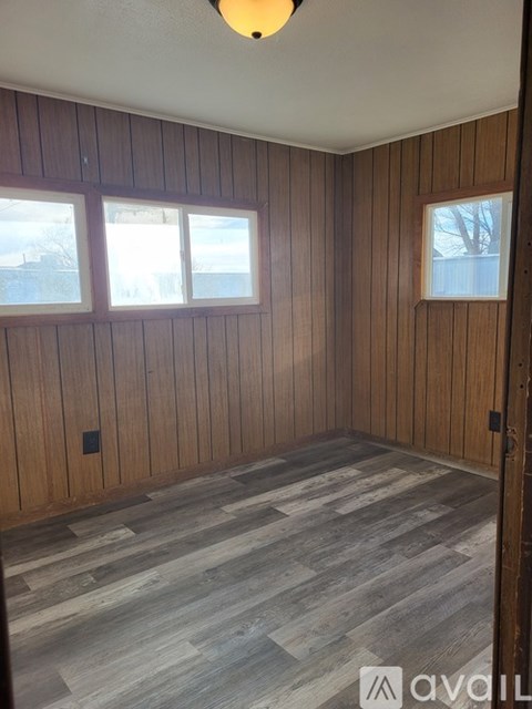 A room with wooden walls and a grey floor.