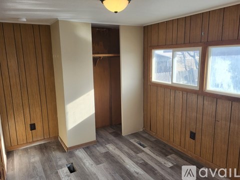 A room with wooden walls and a window.