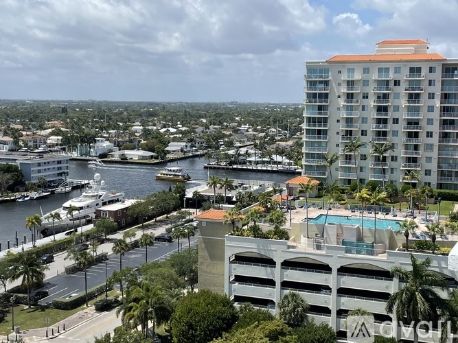 A view of a city from a high vantage point with a large body of water and boats.