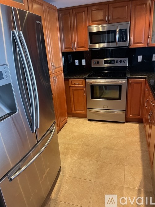 A kitchen with a stainless steel refrigerator and a stove with an oven.