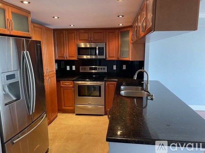 A kitchen with wooden cabinets and a black countertop.