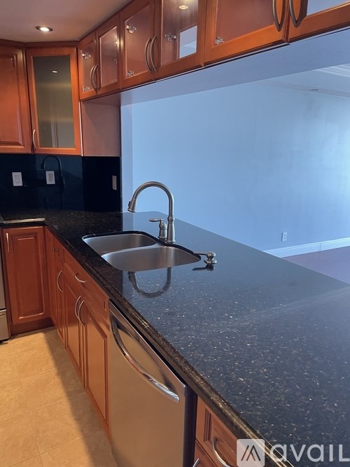 A kitchen with wooden cabinets and a granite countertop.