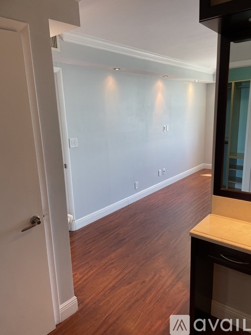 A hallway with wood floors and white walls.
