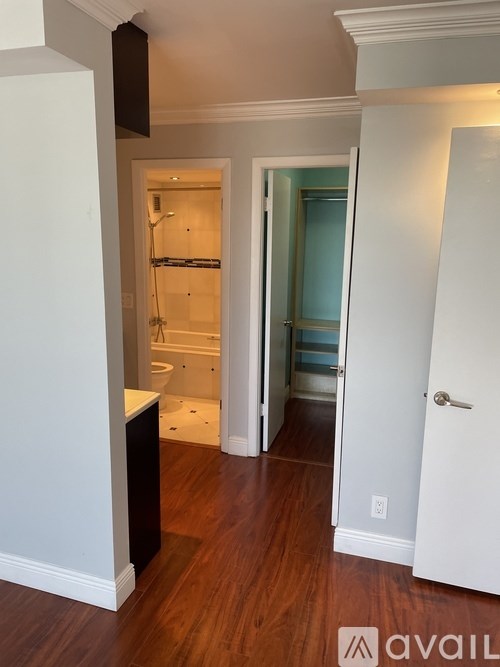 A bathroom with a toilet, sink, and bathtub is open to a hallway.