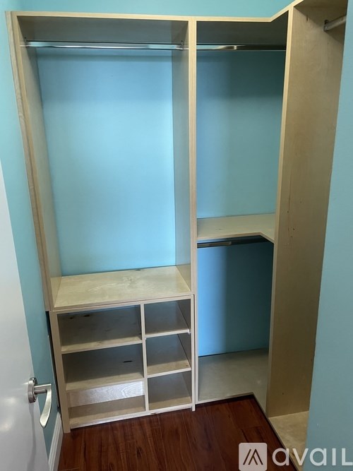 A white closet with shelves and drawers is open.