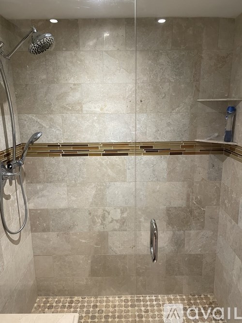 A shower area with a tiled wall and floor.