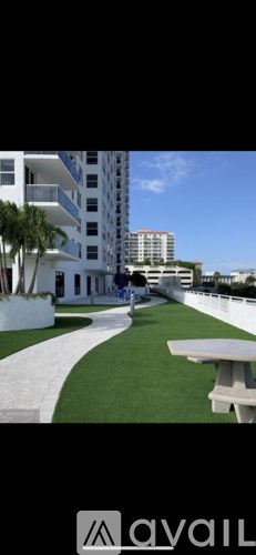 A white building with a green lawn in front.
