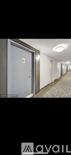 A hallway with a door on the left and a logo on the right.