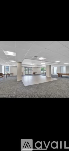 A spacious office room with a carpeted floor and white walls.