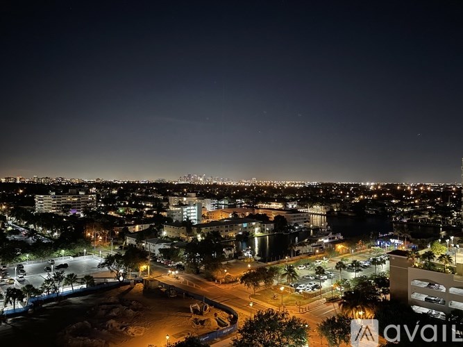 A cityscape at night with a dark sky above.