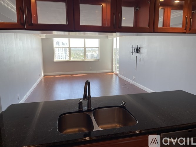 A kitchen with a black countertop and a double sink.