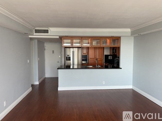 A spacious kitchen with wooden cabinets and a black countertop.