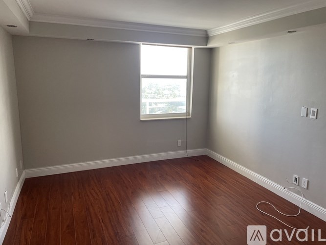 A room with wooden flooring and a window.
