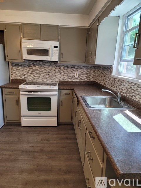 A kitchen with a white oven and brown countertops.