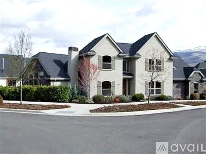 A large, modern house with a driveway in front.