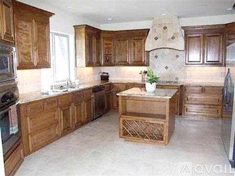 A kitchen with wooden cabinets and a central island.