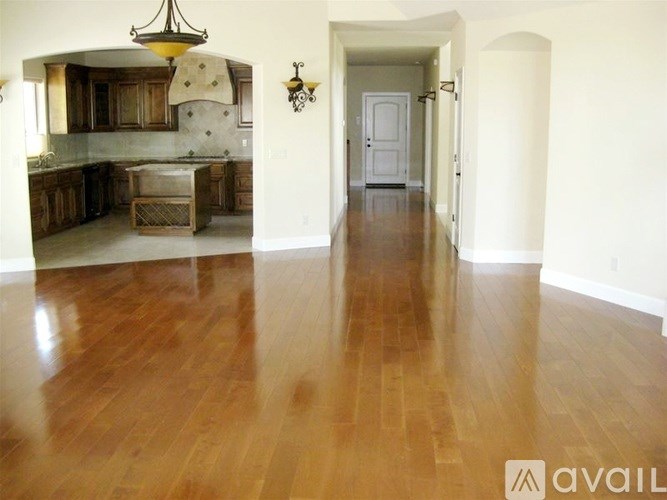 A spacious kitchen with wooden floors and a long hallway.