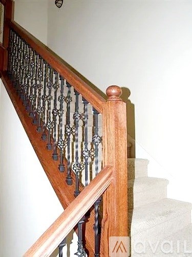 A wooden staircase with a metal railing.