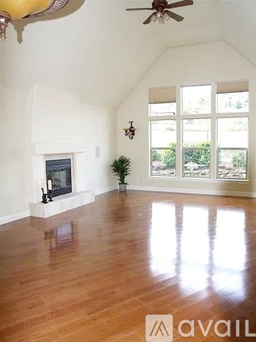A living room with a fireplace and a ceiling fan.