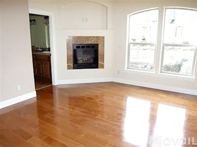 A living room with a fireplace and hardwood floors.