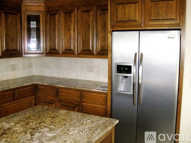 A kitchen with wooden cabinets and a granite countertop.