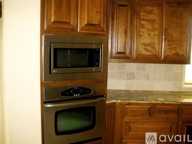 A stainless steel microwave oven with a digital display is placed on top of a stainless steel oven.