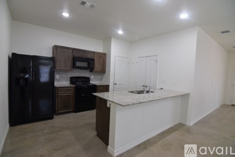 A kitchen with black appliances and a white countertop.