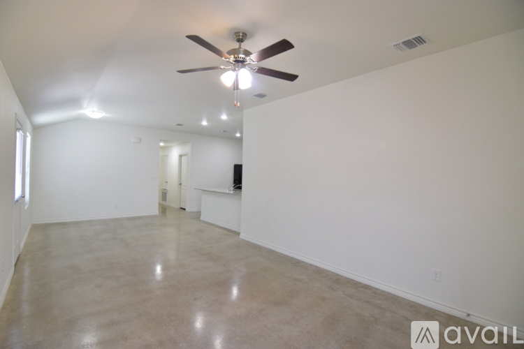 A spacious room with a ceiling fan and a light source.