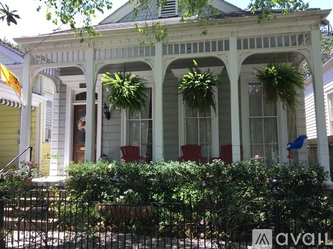 A white house with a porch and a sign that says "available".