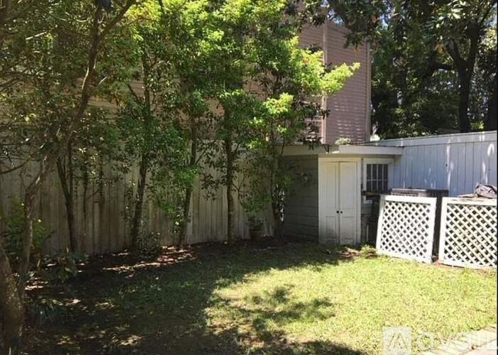 A backyard with a white fence and a shed.