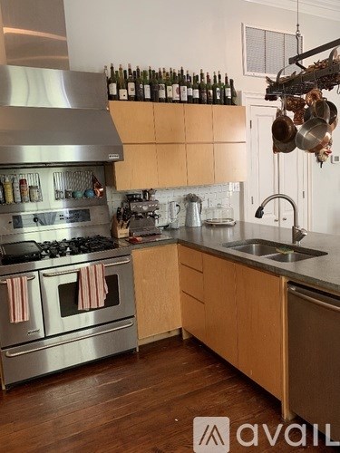 A kitchen with wooden cabinets and a stainless steel range hood.